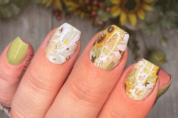 Nails with floral NAIL WRAP design and green accents, held against a blurred natural background.