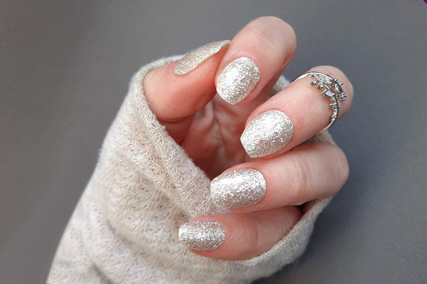 White glitter nail wraps on nails.