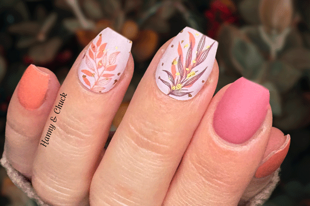 Nails with pink and orange floral nail wrap design on a blurred natural background