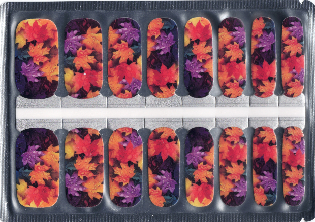 A sheet of nail polish wraps featuring a bold autumn design with overlapping Canadian maple leaves in deep red, fiery orange, golden yellow, and plum purple tones. Each wrap shows a stained-glass style pattern of colourful fall leaves.